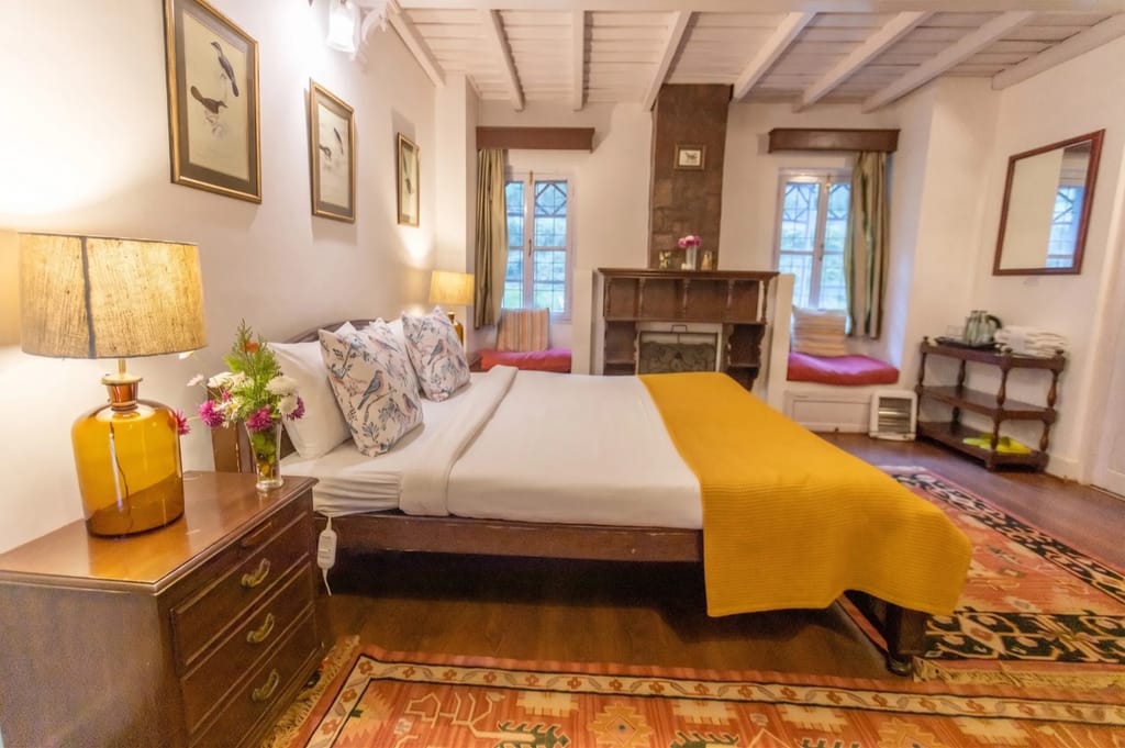 Cuckoo room with yellow throw and stone fireplace