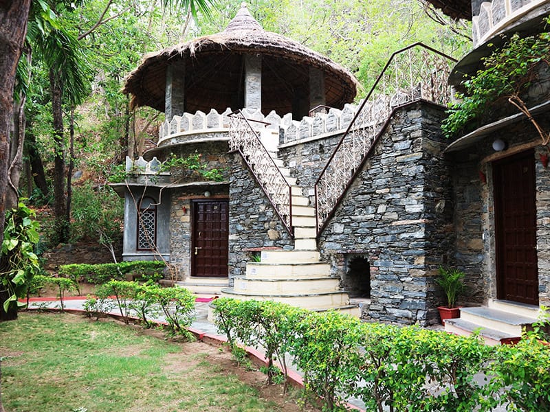 Round stone cottage with thatched roof and external stair