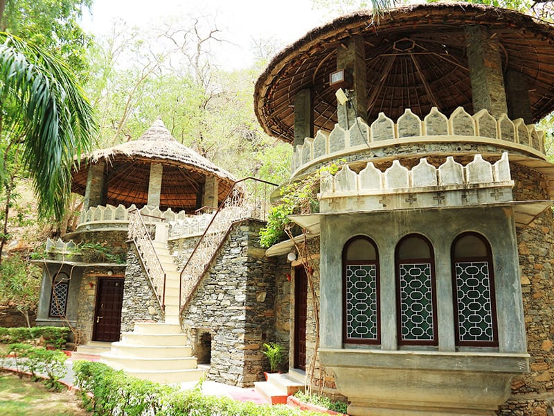 Two stone pavilions with conical thatch and lattice windows