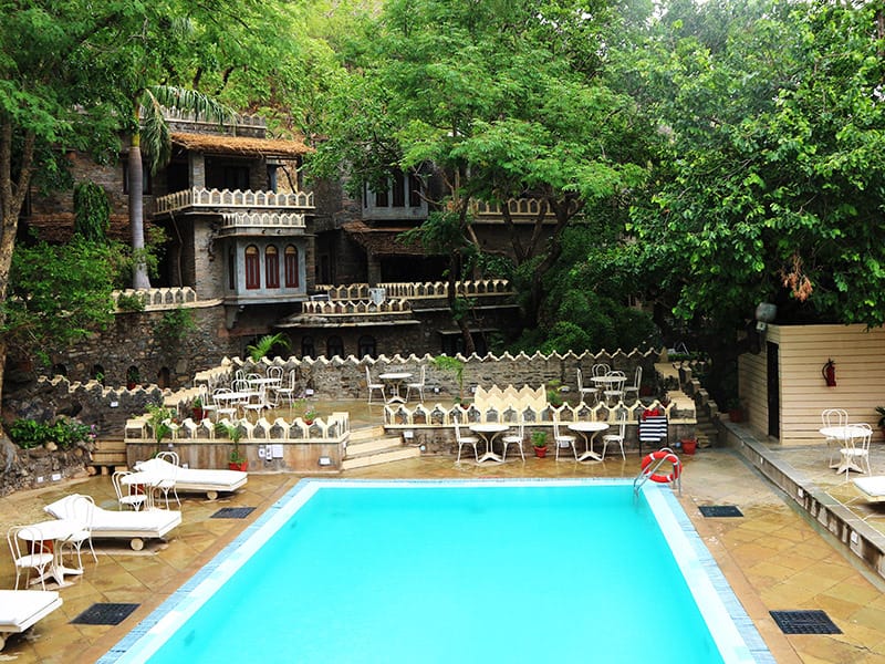 Swimming pool with loungers below stone terraces