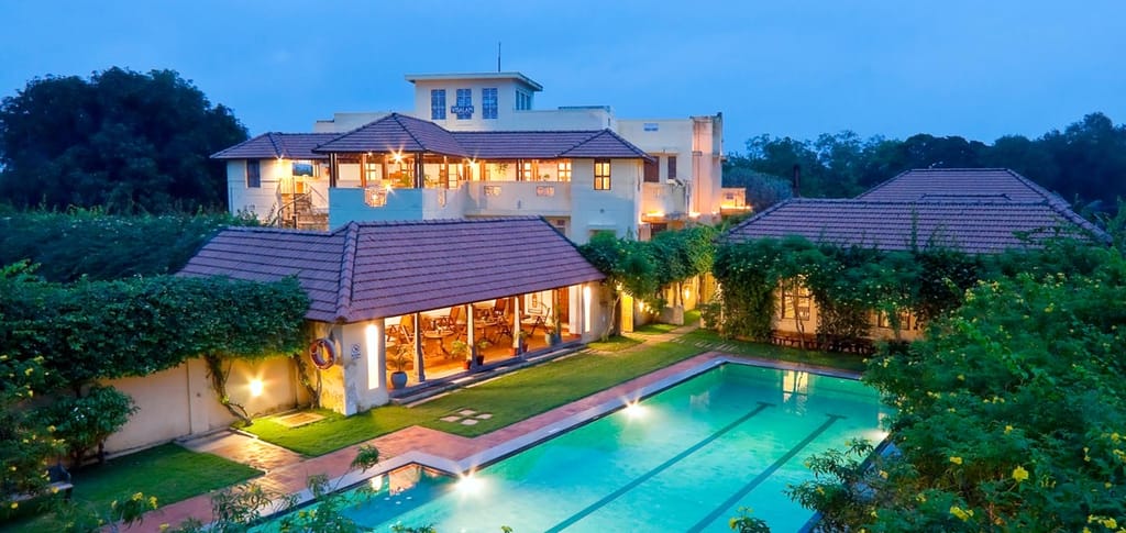 Mansion and lit pool at dusk