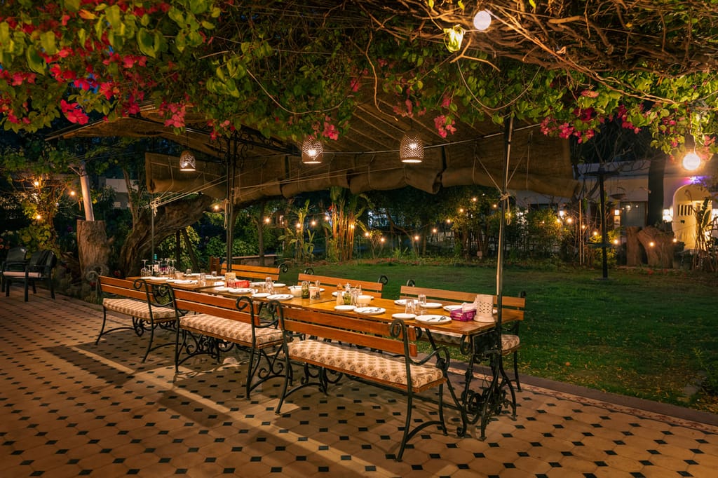 Dinner laid under the bougainvillea in the garden at night, Lutyens Bungalow, New Delhi