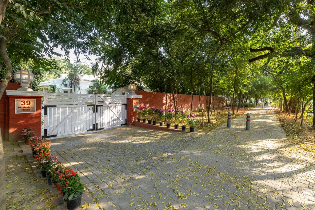 The white gate of 39 Prithviraj Road under the trees, Lutyens Bungalow, New Delhi