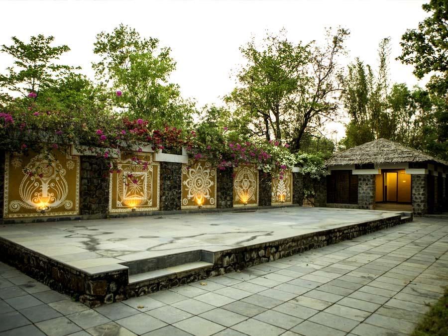 The stone facade and its water channel, bougainvillea over the wall