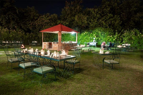 The lawn laid for dinner at night under a pavilion