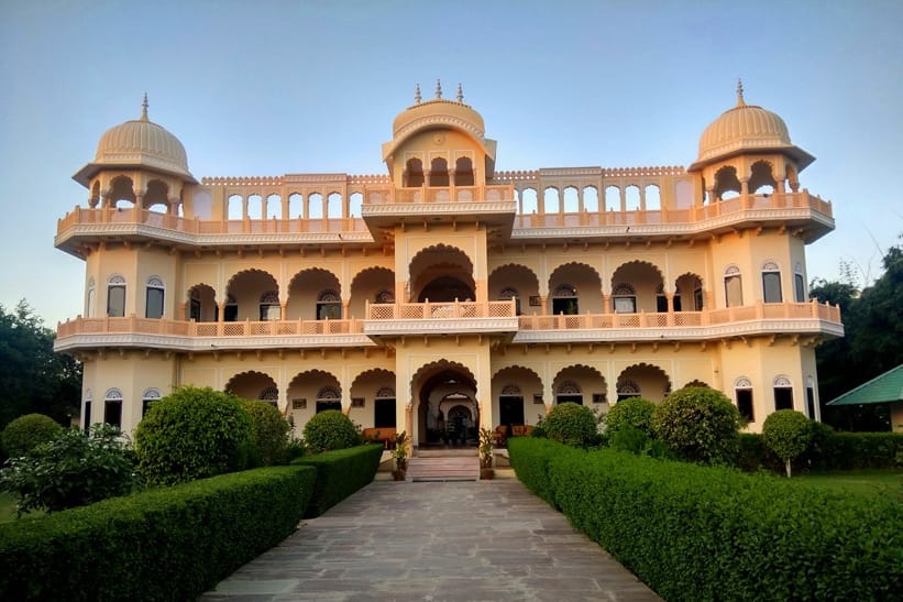 The front of Ranthambhore Heritage Haveli by day, garden tables on the lawn