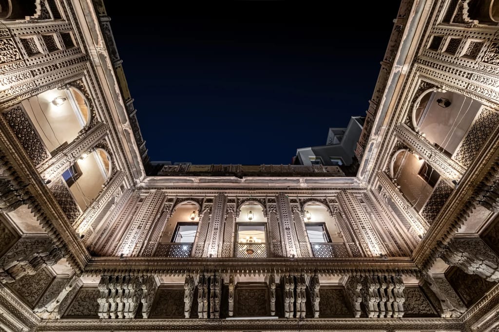 Carved jharokha balconies around the courtyard at night