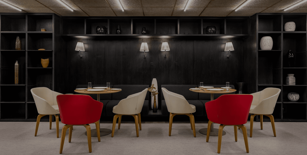 Jigsaw restaurant with red and cream chairs against dark shelving