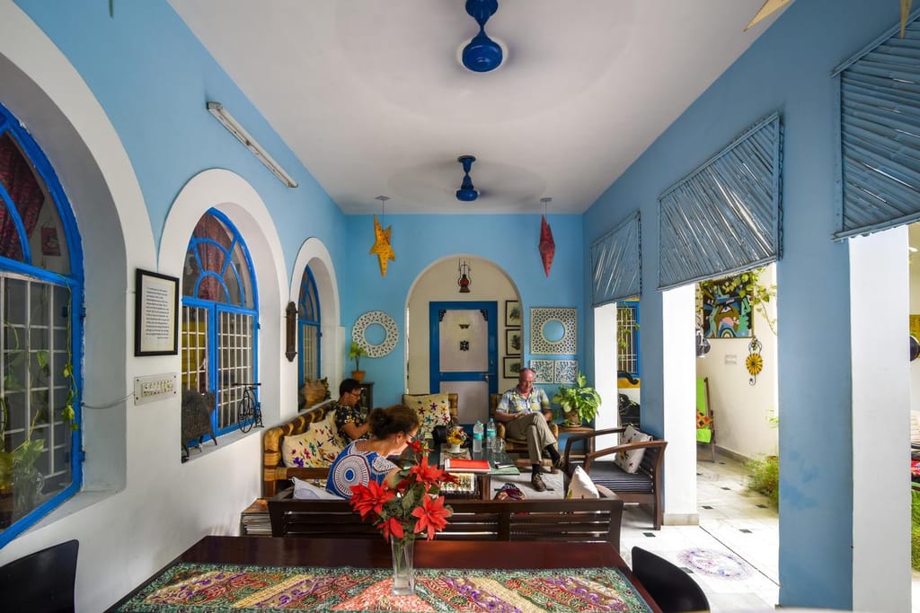 Blue-walled lounge with arched openings, rugs and family seating