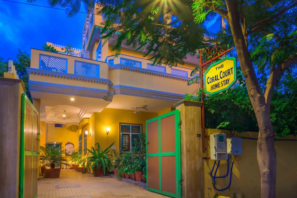 Entrance gate with Coral Court Home Stay signboard and greenery