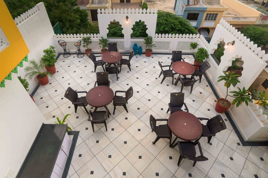 Crenellated second-floor terrace with round tables and planters