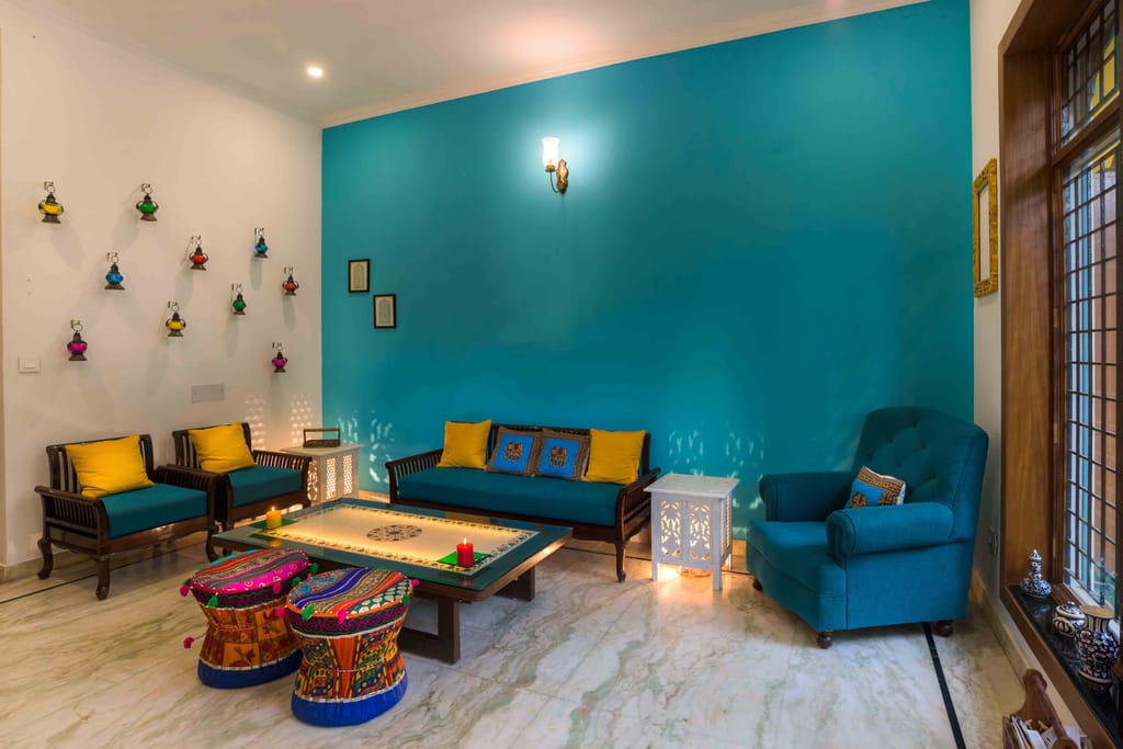 Sitting room with teal walls, sofas and hand-painted stools