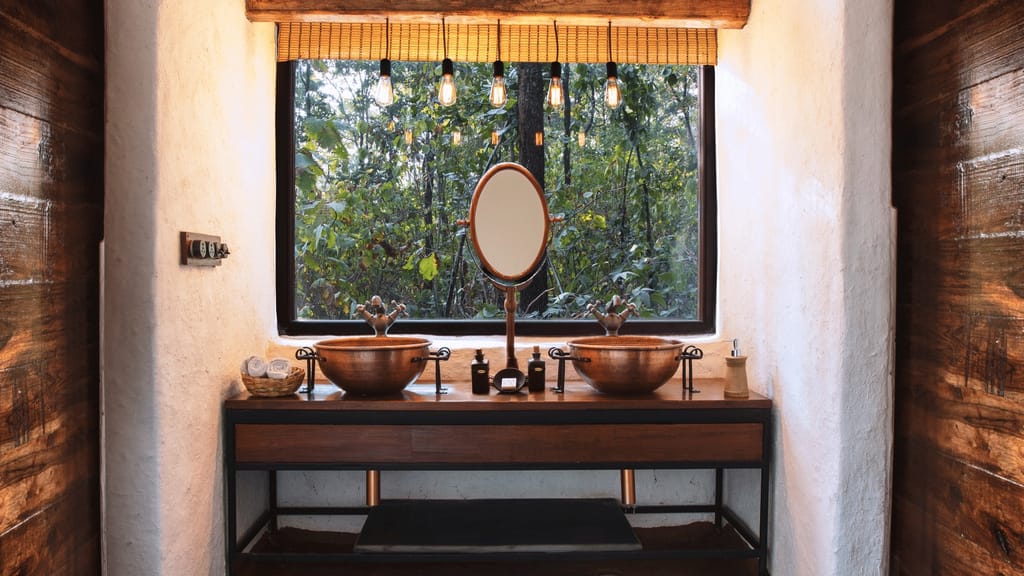 Luxury Tent — bathroom with twin copper basins under a forest-facing window at Reni Pani Jungle Lodge, Satpura
