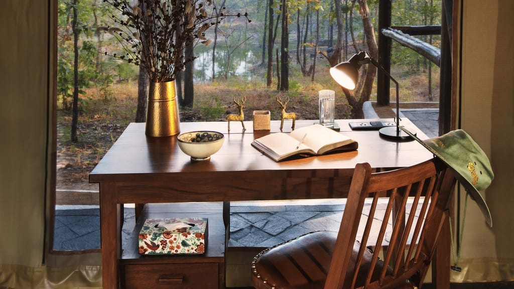 Luxury Tent — writing desk with lamp by the mesh window looking onto the forest at Reni Pani Jungle Lodge, Satpura