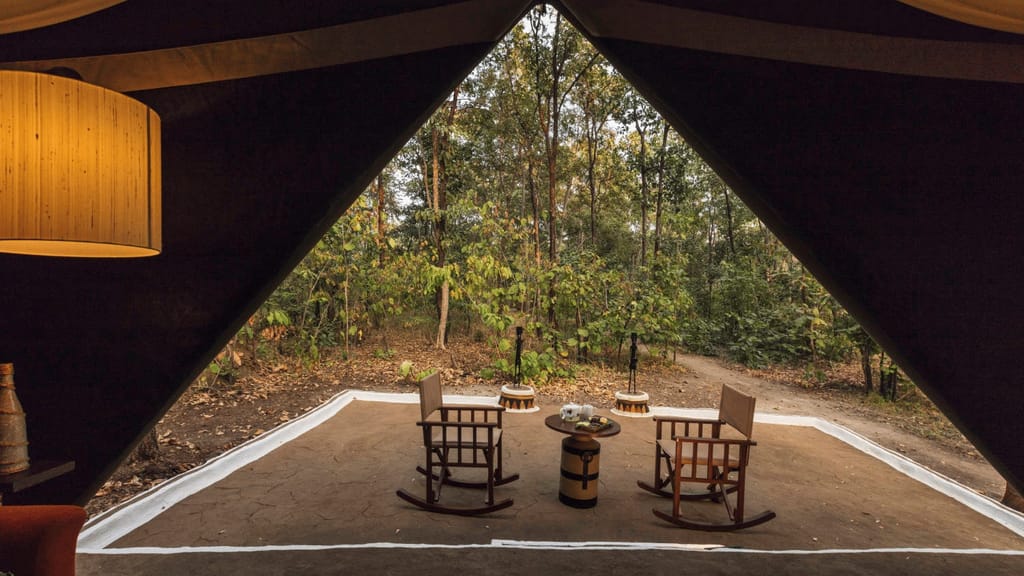 Luxury Tent — rocking chairs and tea table on the veranda facing the forest at Reni Pani Jungle Lodge, Satpura