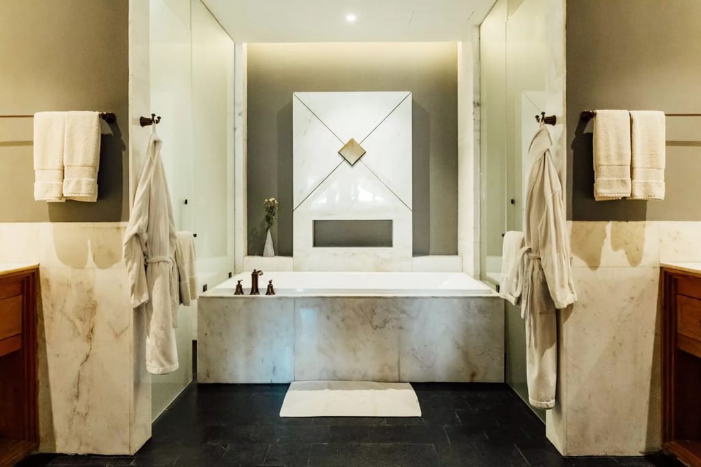 Terrace Room marble bathroom with a bathtub, robes and towels at Bhutan Spirit Sanctuary, Paro