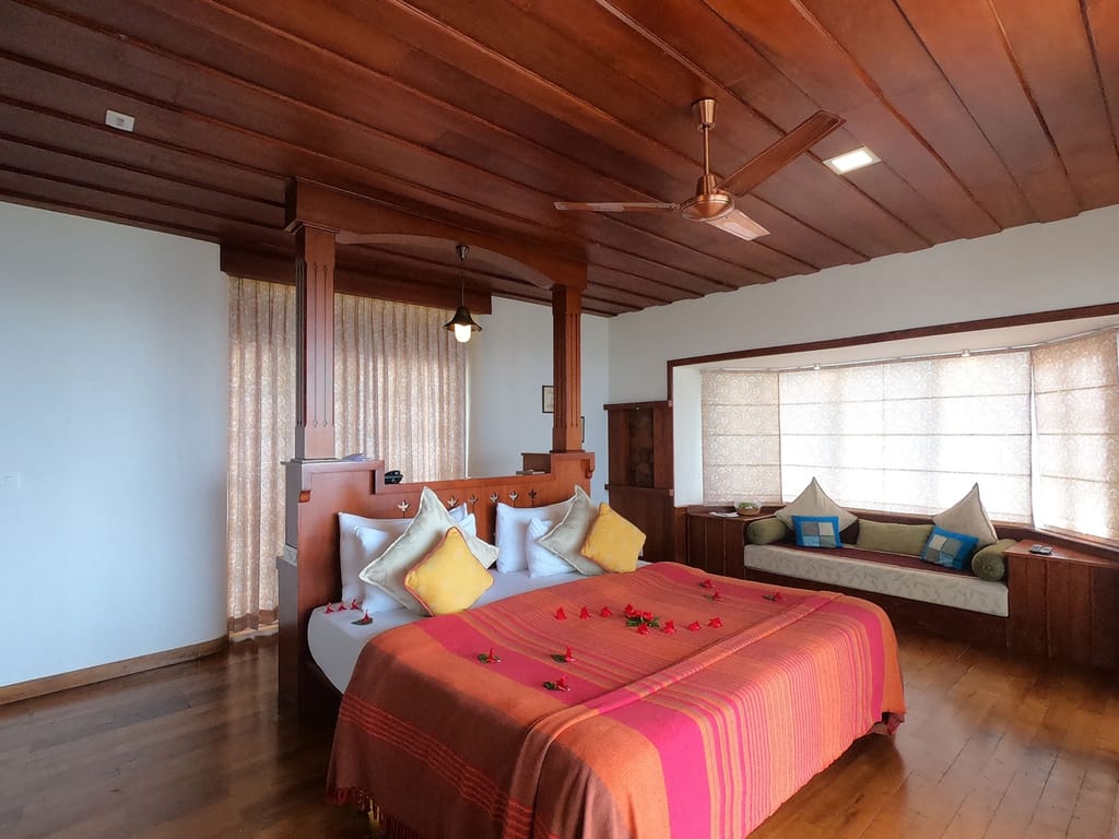Classic Cottage with Jacuzzi room with king bed, flower petals and cushioned window seat, Spice Tree Munnar, Munnar