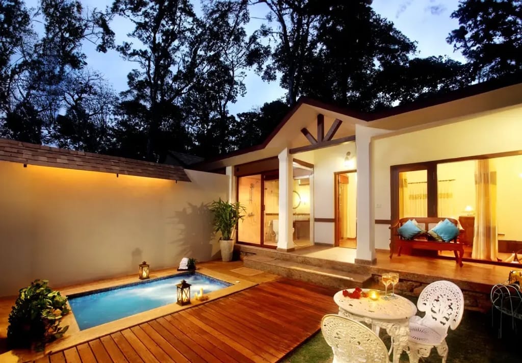 Plunge Pool Villa private walled courtyard at dusk with plunge pool, deck and verandah seating, Carmelia Haven, Thekkady