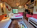 Inside a Tathastu Pench treehouse, the bed under a thatched roof