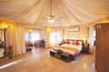 Inside a luxury tent at Tathastu Pench, the draped ceiling over the bed