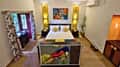A cottage bedroom at Tathastu Kanha with a bird print above the bed