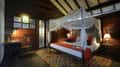 Inside a treehouse at Pench Tree Lodge, the four-poster bed under its net