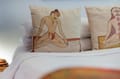 Cushions printed with yoga figures on a Deluxe Room bed at The Malabar House