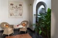 Wicker chairs and a framed painting in the sit-out of a Deluxe Room at The Malabar House