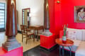 Roof Garden Suite sitting area at The Malabar House with carved stone column, writing desk and red walls