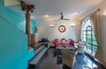 Living room of The Malabar Suite at The Malabar House, turquoise walls, arched window and wicker armchairs