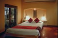 Cottage Room at Old Harbour Hotel: double bed with red cushions beside glazed doors opening to the garden