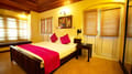 Tea Bungalow, Fort Kochi: Heritage Deluxe Room with wooden bed, pink throw and cushions, bamboo blinds and timber ceiling