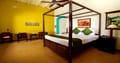 Tea Bungalow, Fort Kochi: Heritage Premium Room with dark wood four-poster bed, green cushions and seating area