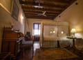 Deluxe Room at The Old Courtyard Hotel: four-poster bed with net, exposed beams, antique desk and lamp