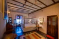 Deluxe Room at The Old Courtyard Hotel with four-poster bed, wooden doors and a long patterned rug