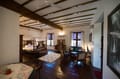 Suite Room at The Old Courtyard Hotel with four-poster bed, cane seating and windows on two sides