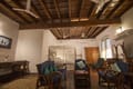 Sitting area of the Suite Room at The Old Courtyard Hotel with cane armchairs, antique desk and mosquito-netted bed