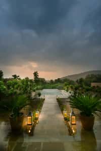 Lantern-lit pool and stone walkway at dusk