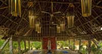 Open yoga shala under a timber and thatch roof