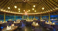 Restaurant laid for dinner under a thatched dome