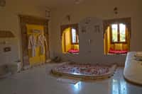 Bathroom with a sunken tub, carved stone doorway and twin arched window seats