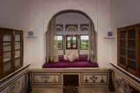 Window seat below a stained glass fanlight, floral panels painted along the base
