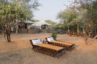 Wooden daybeds outside the canvas tents