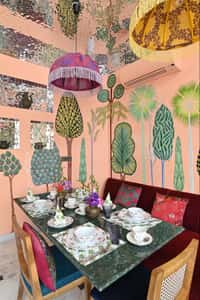 Cafe table set against painted tree walls