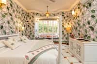 Four-poster bed in a lotus-painted room