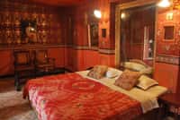 Double bed below a gilt framed mirror