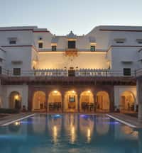 Swimming pool and lit arcade at dusk
