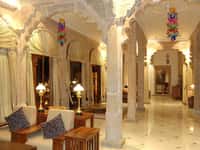 Pillared corridor with lamps and cushioned benches