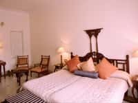 Bedroom with four-poster bed and armchairs
