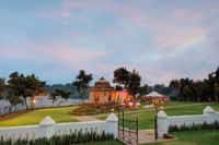 Stone cenotaph on the lawn at dusk with the river beyond